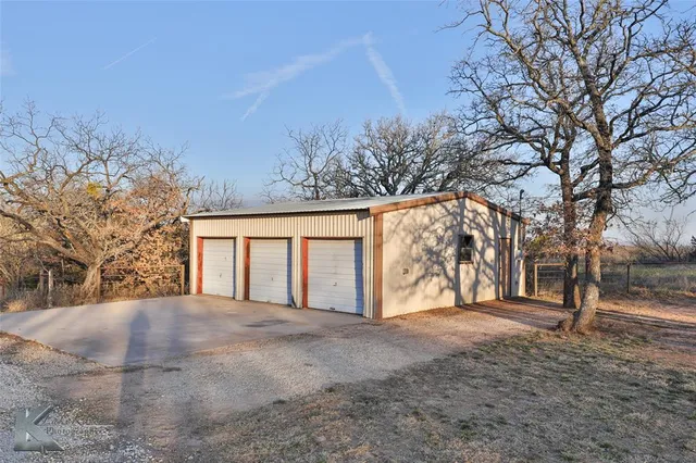 a view of empty house with tree and wooden fence