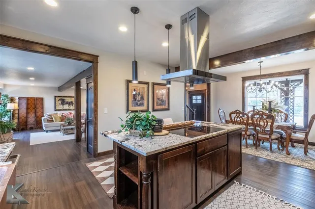 a open kitchen with stainless steel appliances granite countertop a stove refrigerator and chairs