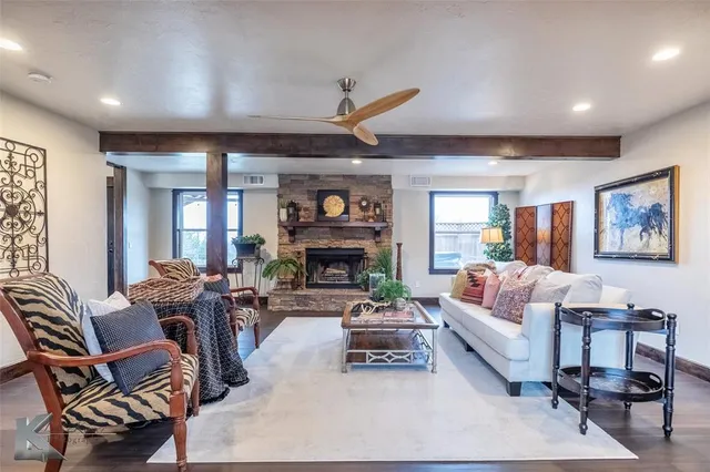 a living room with furniture a fireplace and a large window