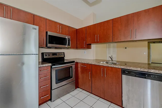 a kitchen with kitchen island granite countertop a sink and steel appliances