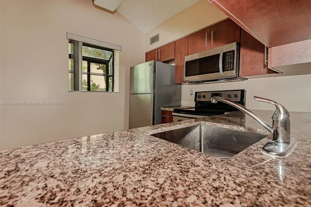 a kitchen with granite countertop cabinets and entryway