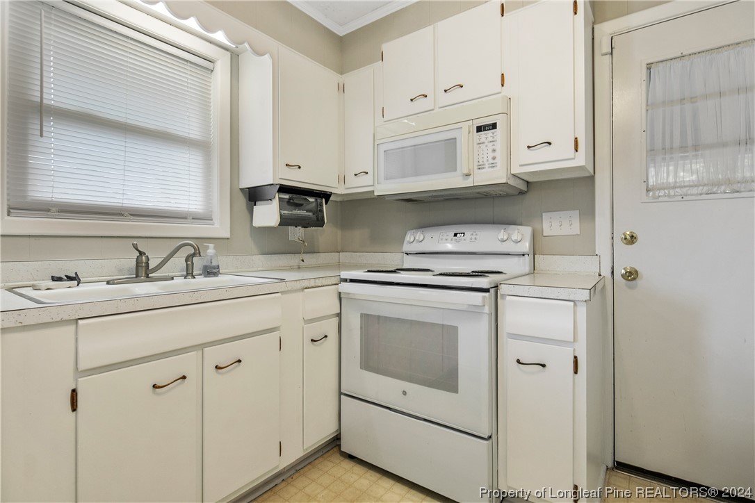 636 Pleasant Loop Fayetteville, NC 28311 - Photo 18 of 40 a kitchen with white cabinets white stainless steel appliances and sink