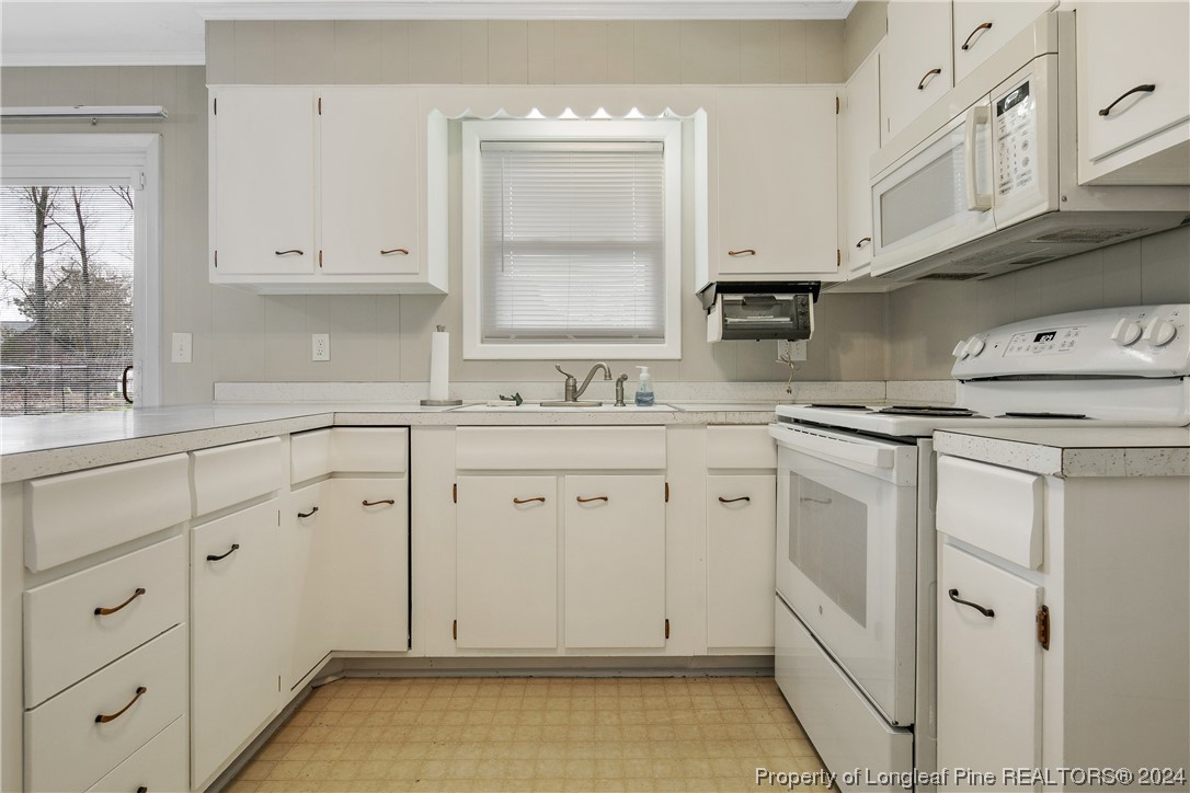 636 Pleasant Loop Fayetteville, NC 28311 - Photo 19 of 40 a kitchen with white cabinets and white appliances