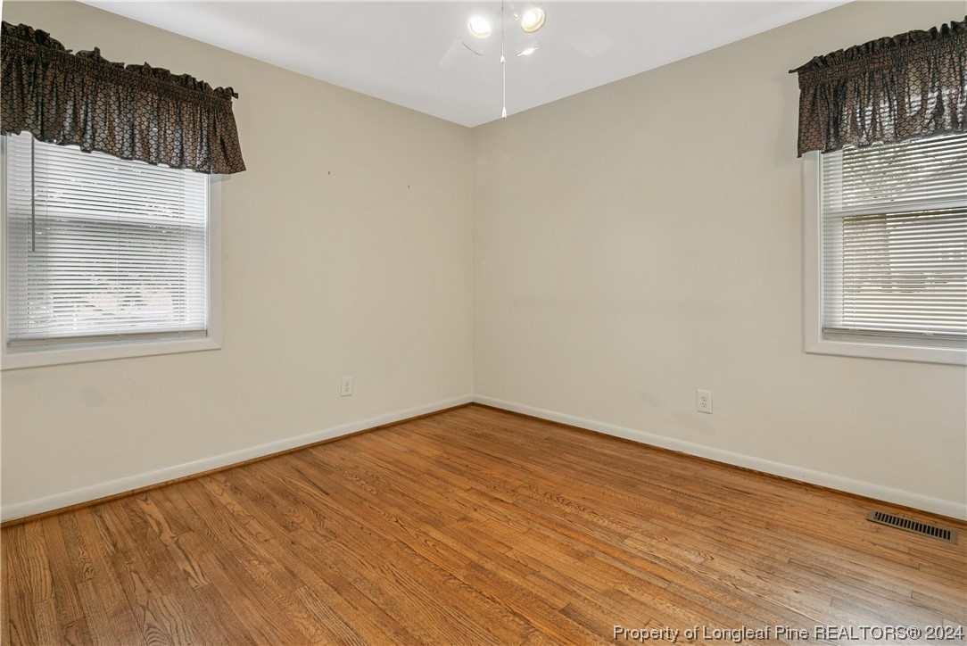 636 Pleasant Loop Fayetteville, NC 28311 - Photo 22 of 40 an empty room with wooden floor and windows