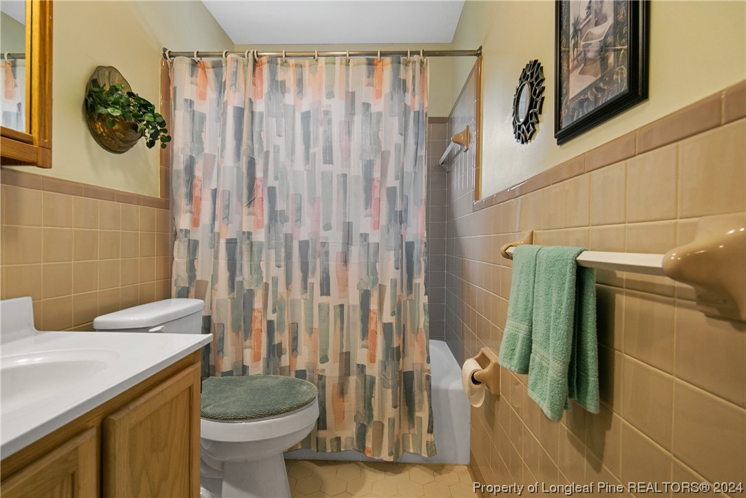 636 Pleasant Loop Fayetteville, NC 28311 - Photo 31 of 40 a bathroom with a granite countertop sink a toilet and a shower curtain
