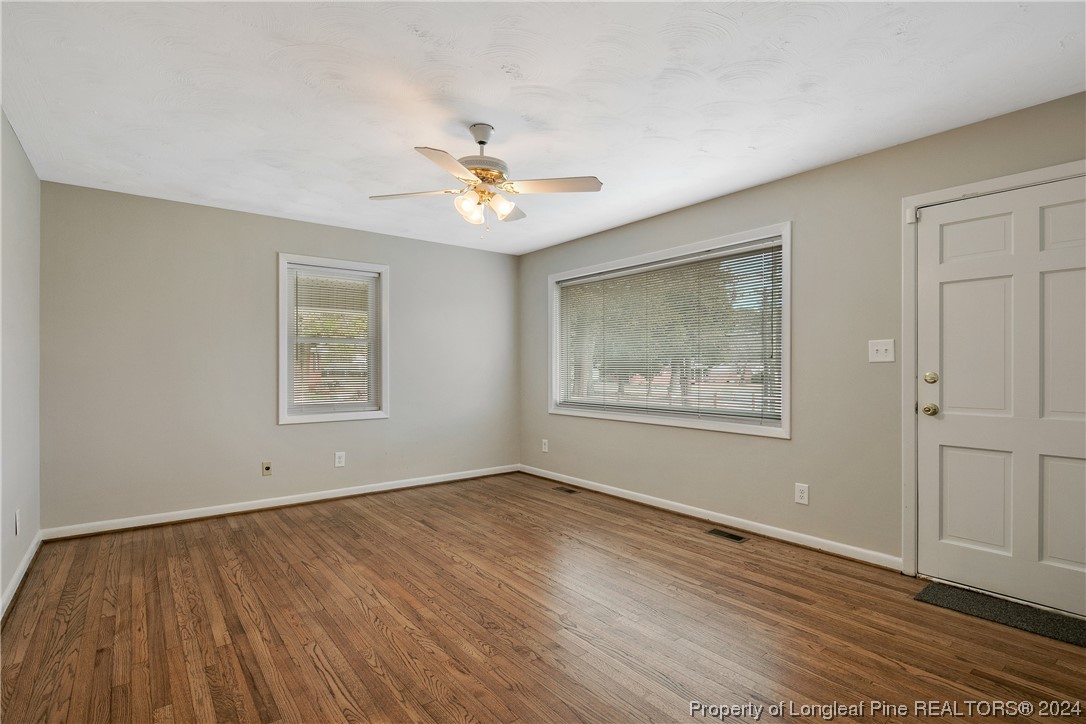 636 Pleasant Loop Fayetteville, NC 28311 - Photo 8 of 40 a view of an empty room with a window and wooden floor
