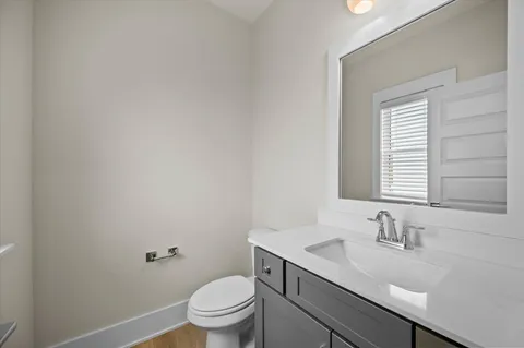 an empty room with wooden floor cabinet and windows
