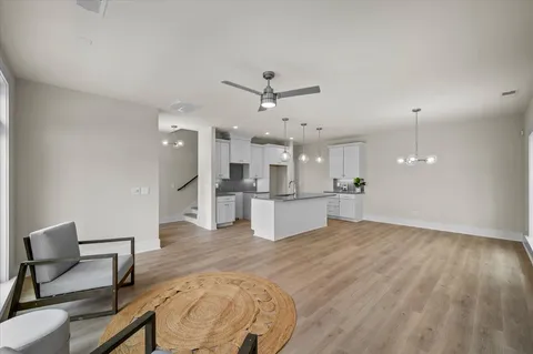 a large kitchen with sink a refrigerator and wooden floor