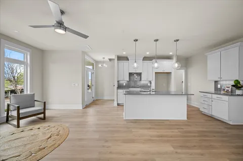 a kitchen with stainless steel appliances granite countertop a refrigerator a sink a stove and a wooden floors