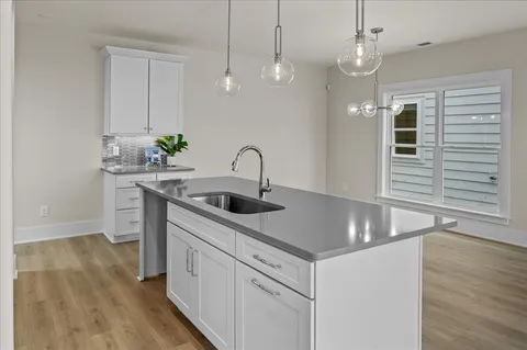 a kitchen with kitchen island a sink a counter space appliances and cabinets