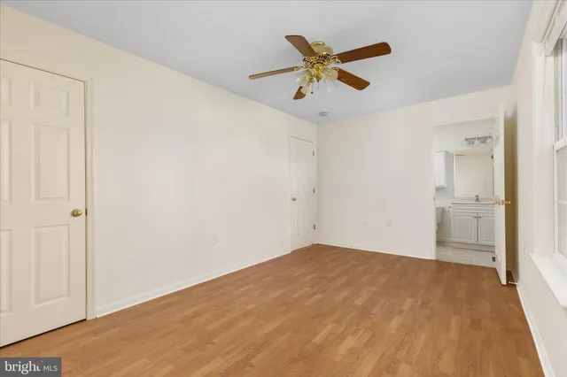 a view of a big room with wooden floor and windows