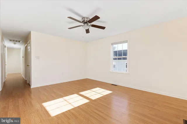 a view of a big room with wooden floor and windows in a room