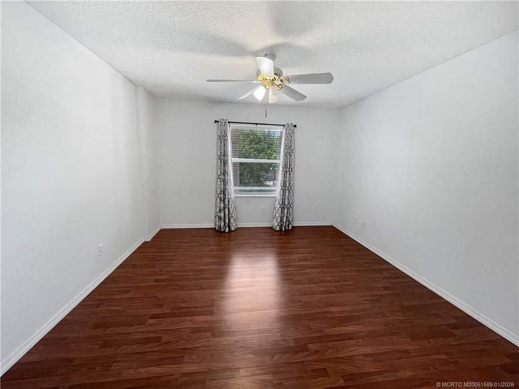 8006 Southwest Yachtsmans Drive Stuart, FL 34997 - Photo 15 of 42 a view of empty room with wooden floor and fan