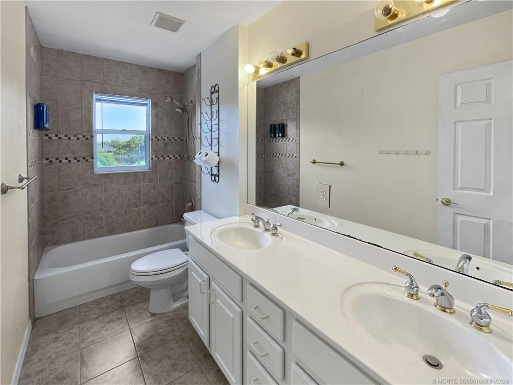 8006 Southwest Yachtsmans Drive Stuart, FL 34997 - Photo 16 of 42 a bathroom with a sink toilet a bathtub and shower
