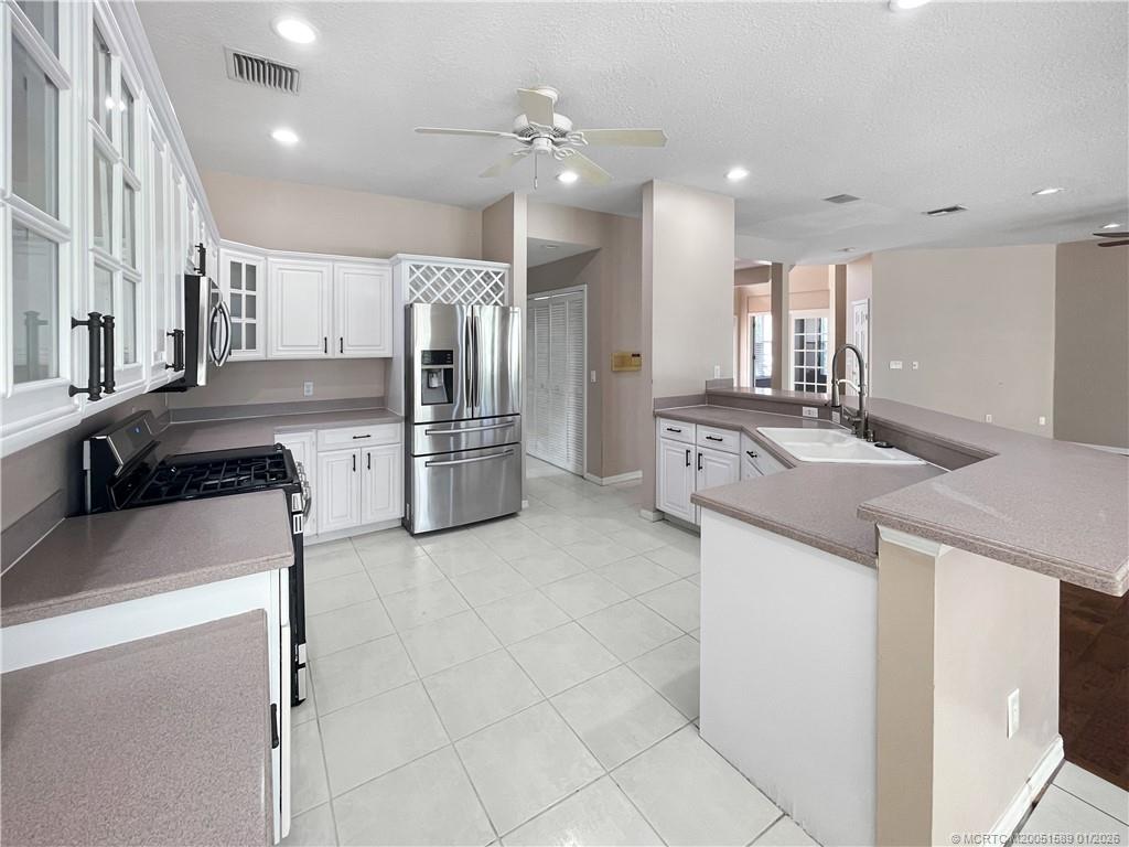 8006 Southwest Yachtsmans Drive Stuart, FL 34997 - Photo 26 of 42 a kitchen with stainless steel appliances granite countertop a sink and a refrigerator