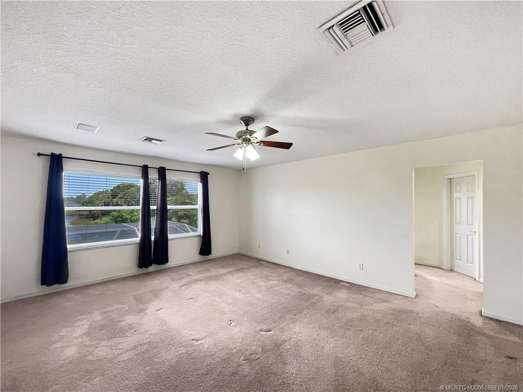 8006 Southwest Yachtsmans Drive Stuart, FL 34997 - Photo 8 of 42 an empty room with windows and chandelier fan