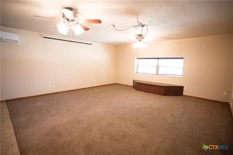 an empty room with a windows and ceiling fan