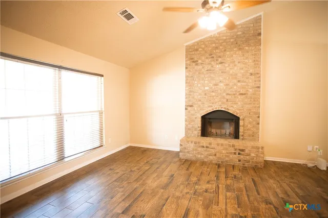 a view of a room with wooden floor and a fireplace