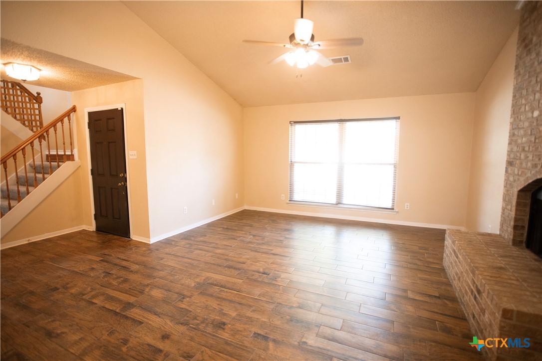 712 Brazos Drive Temple, TX 76504 - Photo 5 of 28 an empty room with wooden floor chandelier fan and windows