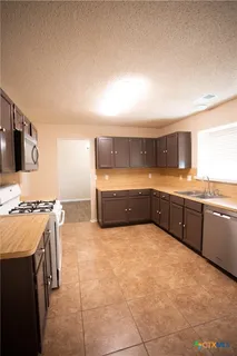 a large kitchen with a stove a sink a microwave and island