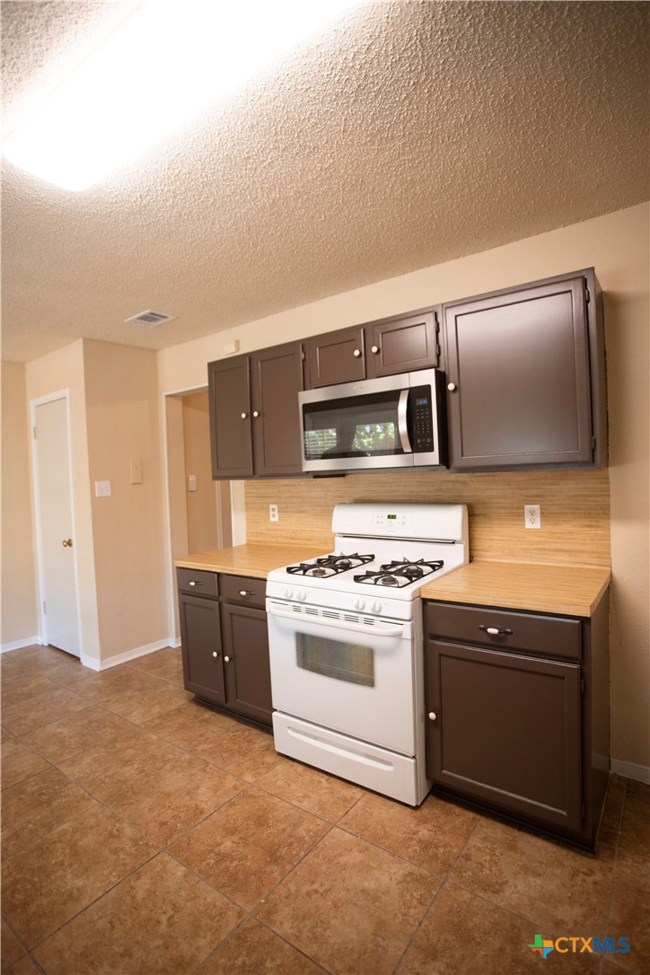 712 Brazos Drive Temple, TX 76504 - Photo 9 of 28 a kitchen with a stove and a microwave