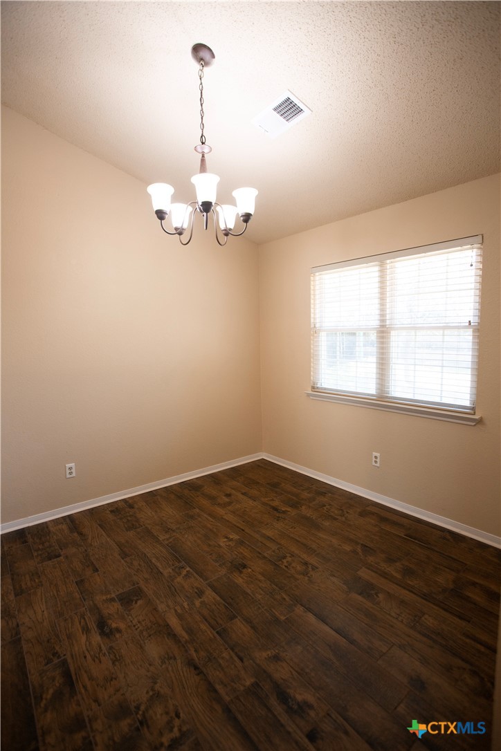 712 Brazos Drive Temple, TX 76504 - Photo 10 of 28 an empty room with wooden floor cabinet and windows