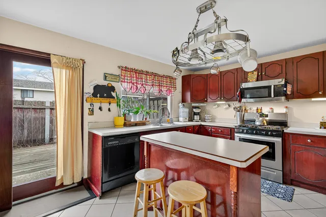 a kitchen with stainless steel appliances kitchen island granite countertop a refrigerator a oven a sink and dishwasher with wooden floor