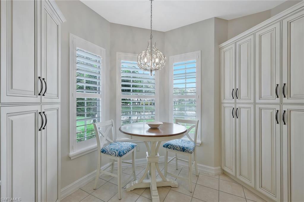 5012 Maxwell Circle, Unit 101 Naples, FL 34105 - Photo 10 of 23 a dining room with chandelier and windows