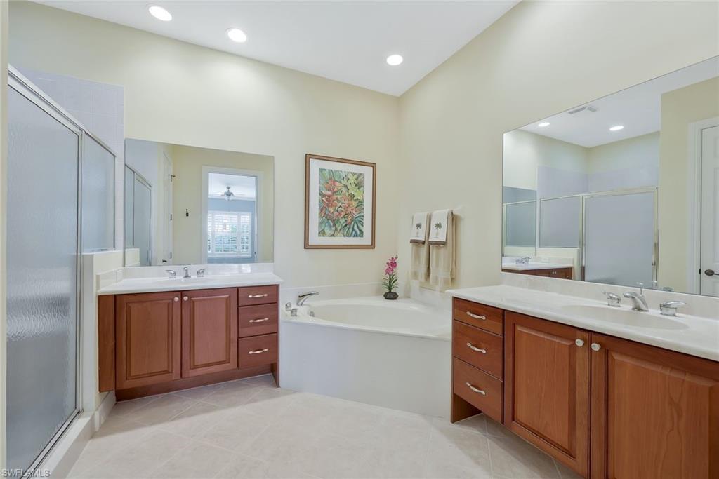 5012 Maxwell Circle, Unit 101 Naples, FL 34105 - Photo 14 of 23 a bathroom with a tub double vanity sink and mirror