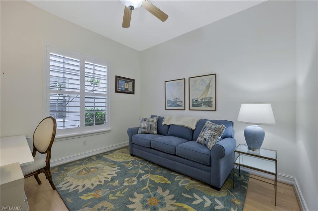 5012 Maxwell Circle, Unit 101 Naples, FL 34105 - Photo 17 of 23 a living room with furniture a window and a chandelier
