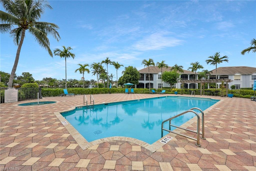 5012 Maxwell Circle, Unit 101 Naples, FL 34105 - Photo 22 of 23 a view of a swimming pool and lounge chairs