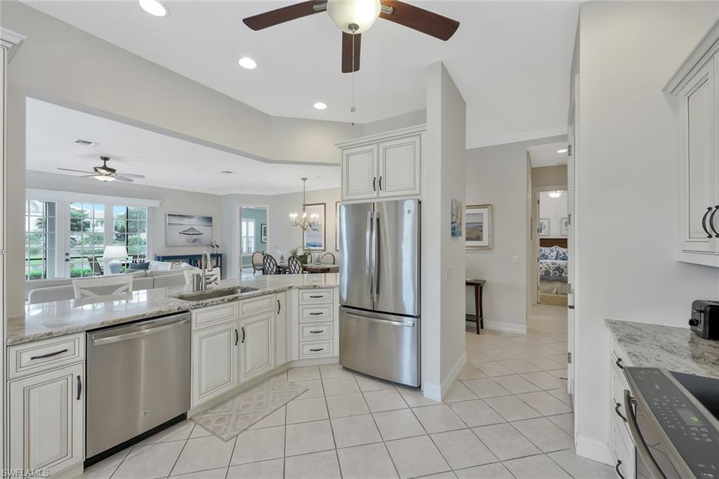 5012 Maxwell Circle, Unit 101 Naples, FL 34105 - Photo 23 of 23 a kitchen with white cabinets and stainless steel appliances