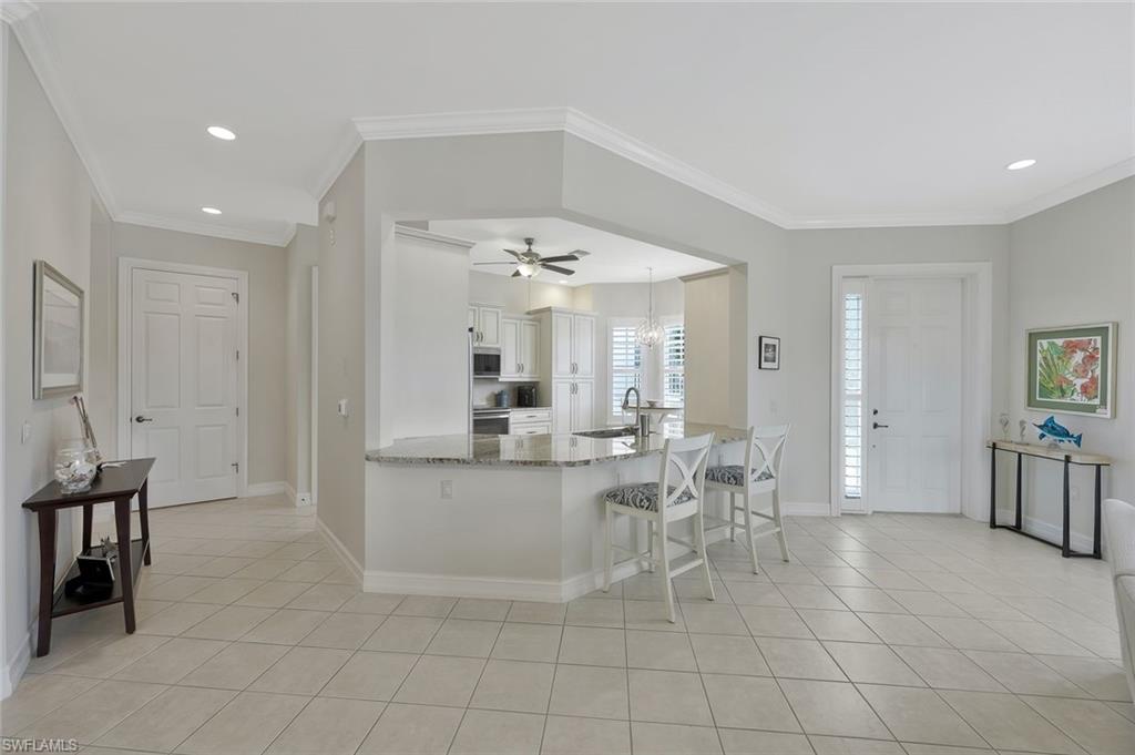 5012 Maxwell Circle, Unit 101 Naples, FL 34105 - Photo 8 of 23 a living room with furniture a dining table and chairs