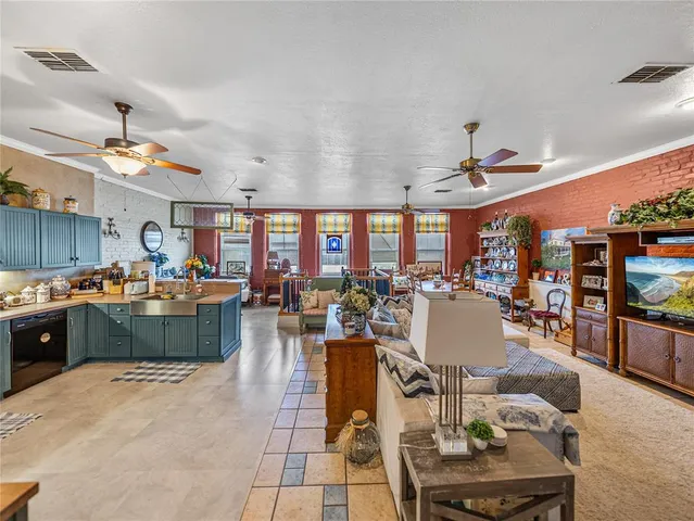 a view of a dining room and livingroom with furniture wooden floor and windows