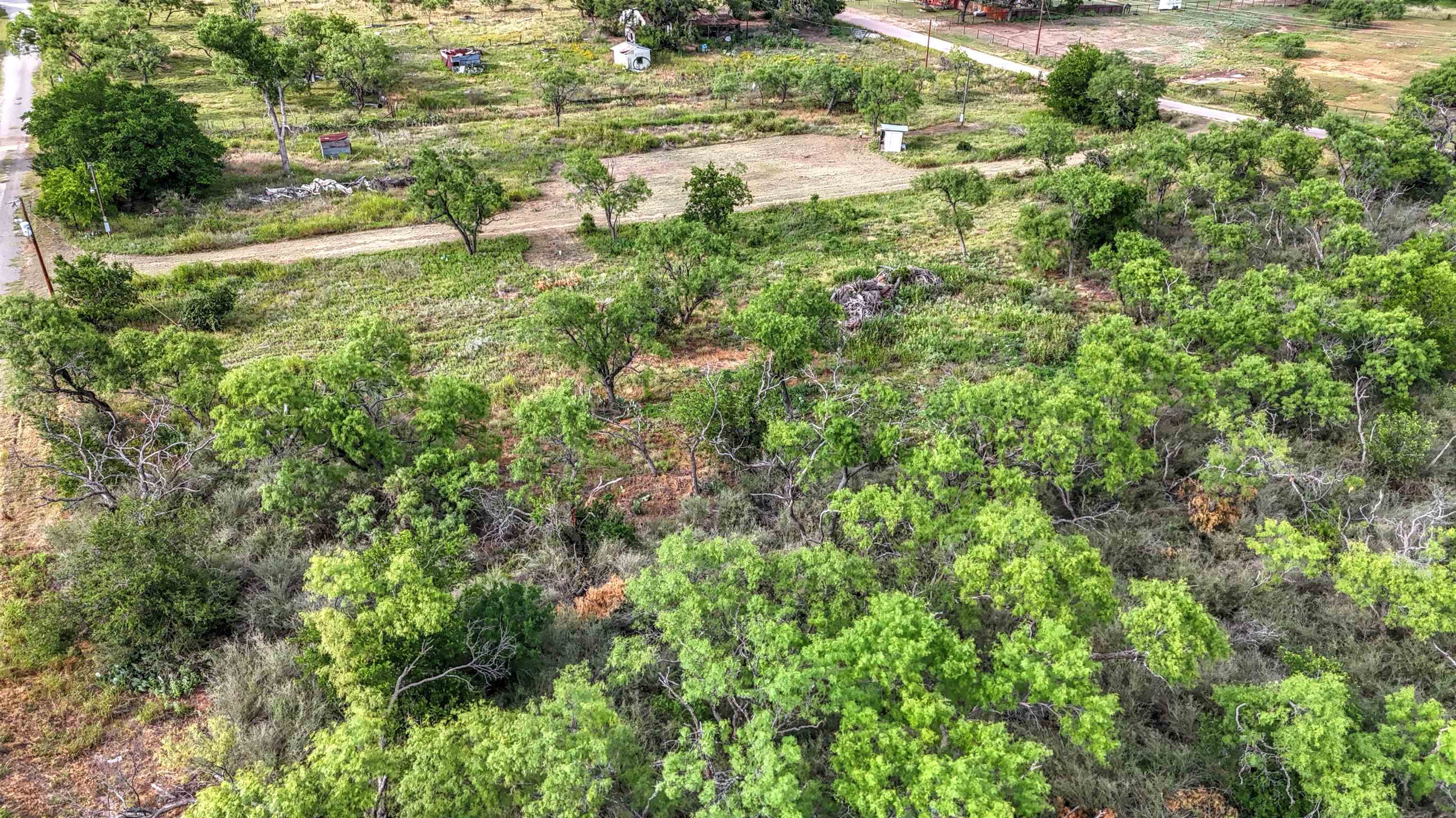 0 East Highway 71 Valley Spring, TX 76885 - Photo 13 of 25 an aerial view of residential houses with outdoor space and trees