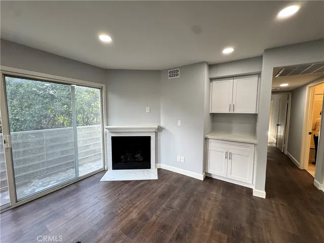 a open kitchen with granite countertop a stove top oven a sink and dishwasher with wooden floor