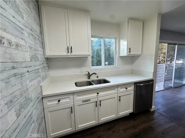a kitchen with stainless steel appliances granite countertop a sink a stove and cabinets