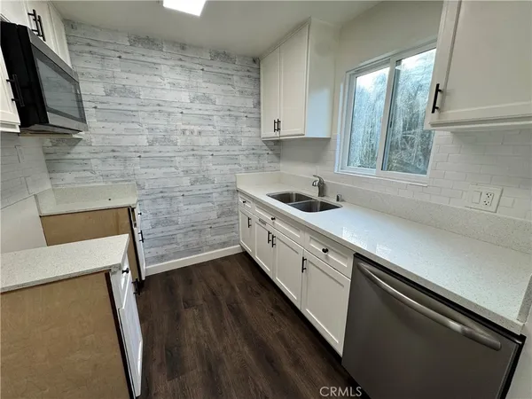 a kitchen with a sink and wooden floor