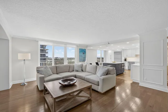 a living room with furniture a flat screen tv and a wooden floor