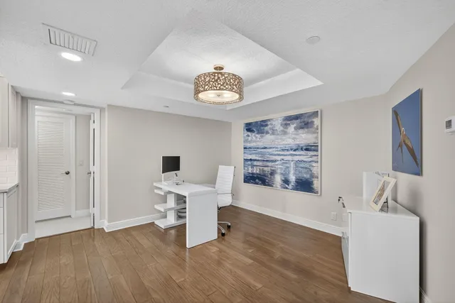 a kitchen with stainless steel appliances granite countertop a sink dishwasher a stove and a refrigerator with wooden floor