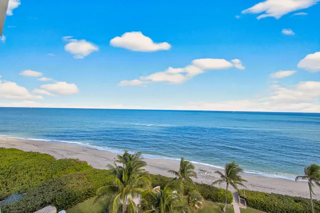 a view of a white building among the street with large buildings