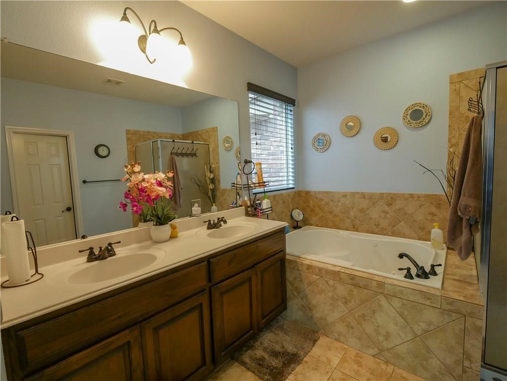 702 South Frontier Lane Cedar Park, TX 78613 - Photo 14 of 30 a bathroom with a tub double vanity sink and mirror
