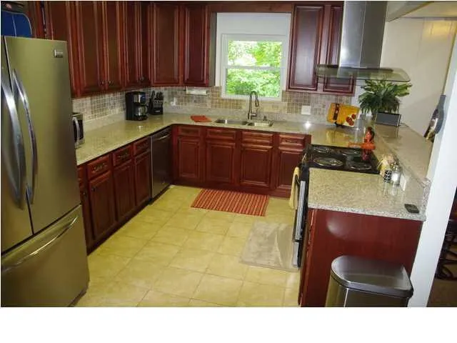 a kitchen with a sink a refrigerator and cabinets