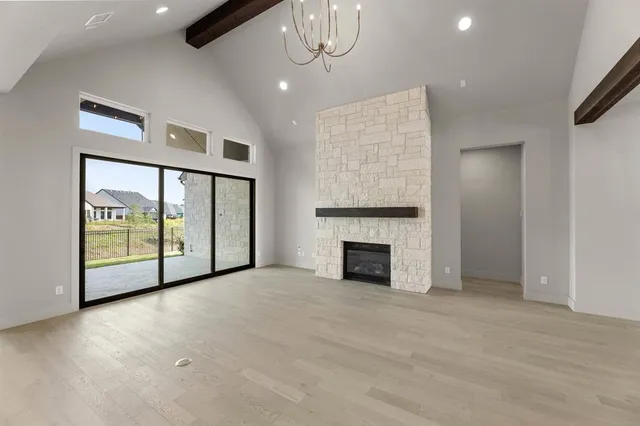 a view of an empty room with a fireplace and a window
