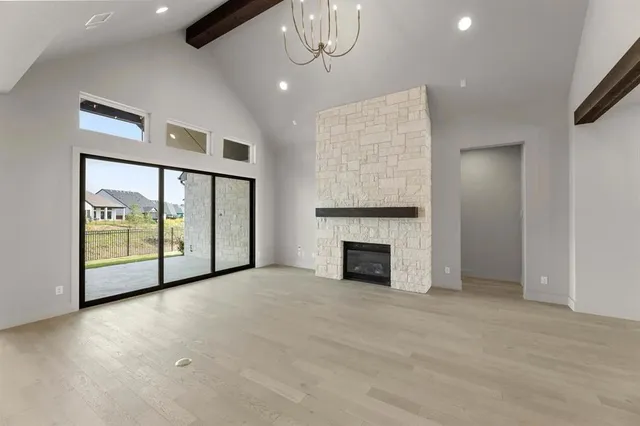 a view of an empty room with a fireplace and a window