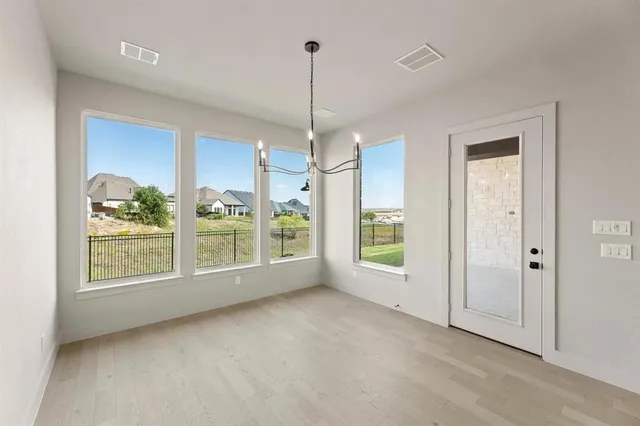 a view of a room with window wooden floor and front door