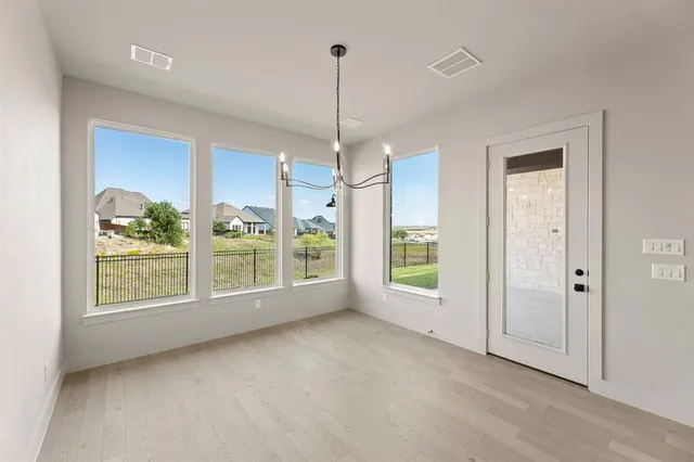 a view of a room with window wooden floor and front door