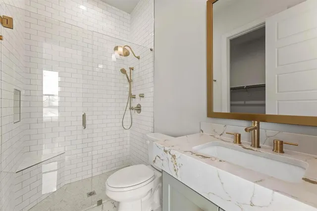 a bathroom with a granite countertop sink toilet and shower