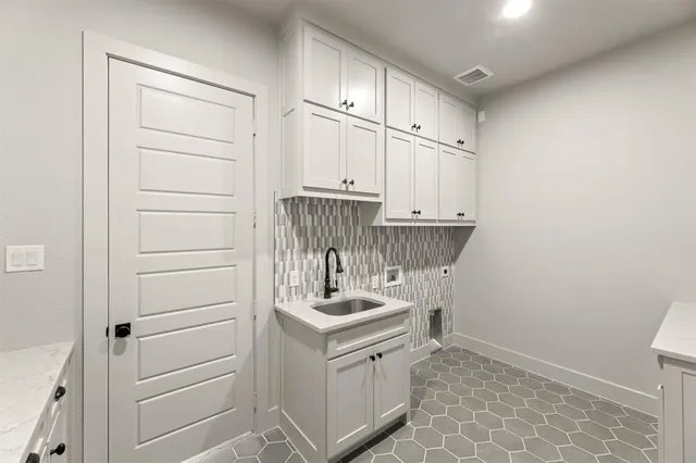 a kitchen with a refrigerator and white cabinets