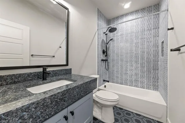a bathroom with a granite countertop sink toilet and shower